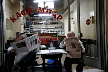 People read their newspapers in central Athens, Greece © Alexandros Michailidis / Shutterstock